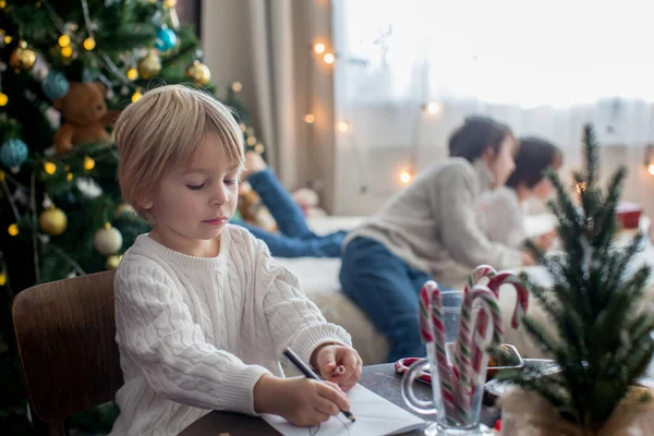 Mutlu aile, çocuklar ve anne, Noel süslemeleri ile süslenmiş rahat bir evde birlikte Noel 'i kutluyoruz.