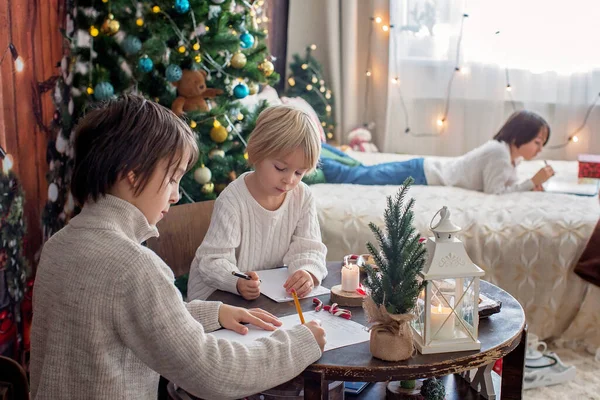 Mutlu aile, çocuklar ve anne, Noel süslemeleri ile süslenmiş rahat bir evde birlikte Noel 'i kutluyoruz.