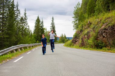 Çocuklar, Norveç 'te boş bir yolda koşuyorlar.