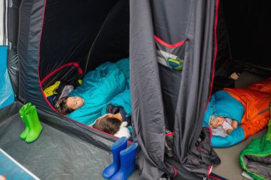 Çocuk, Norveç 'te tatilde bir çadırda uyku tulumunda uyuyor.