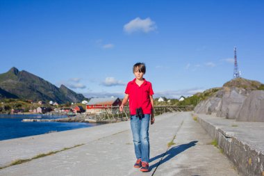 Mutlu aile, Sorvagen, Lofoten Adası, Norveç 'teki rıhtımın keyfini çıkarıyorlar. Çocuklar, güneşli bir günde kayalıklarda koşmak, güzel havanın tadını çıkarmak.