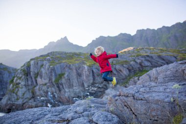 İnsanlar, güneşli bir akşamda Norveç 'in kuzeyindeki Lofoten köyünün güzel manzarasının keyfini çıkarıyorlar.