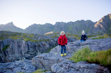 İnsanlar, güneşli bir akşamda Norveç 'in kuzeyindeki Lofoten köyünün güzel manzarasının keyfini çıkarıyorlar.