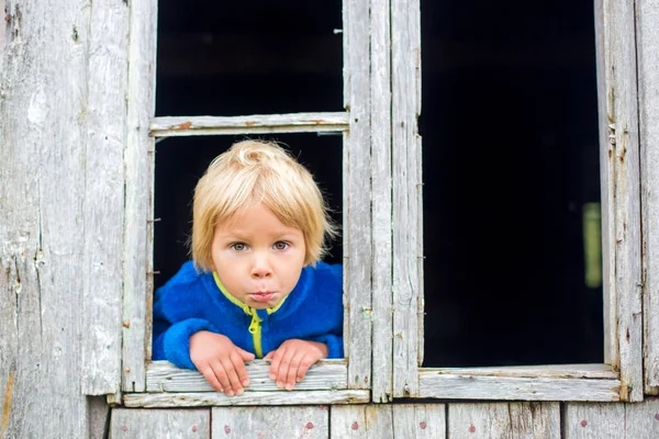 Üzgün Çocuk Eski Bir Binanın Penceresinden Dışarı Bakıyor — Stok fotoğraf