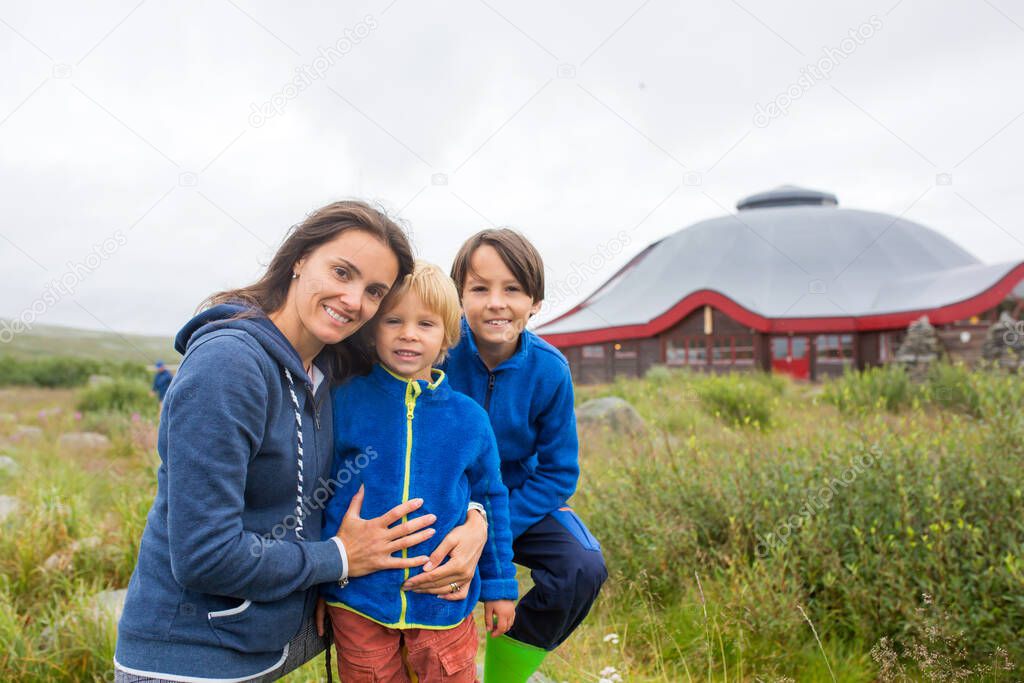 Happy family, standing in front of the Arctic circle centre in Norway, Nordland