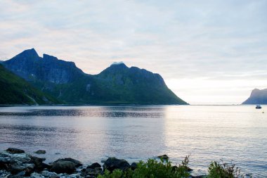 Happy family, standing on a rock and looking over Segla mountain on Senja island, North Norway. Amazing beautiful landscape and splendid nature in scandinavian country