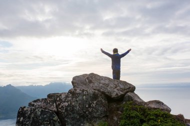 Happy family, standing on a rock and looking over Segla mountain on Senja island, North Norway. Amazing beautiful landscape and splendid nature in scandinavian country