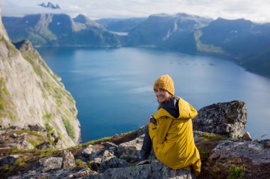 Happy family, standing on a rock and looking over Segla mountain on Senja island, North Norway. Amazing beautiful landscape and splendid nature in scandinavian country