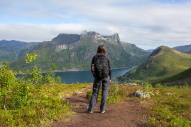 Happy family, standing on a rock and looking over Segla mountain on Senja island, North Norway. Amazing beautiful landscape and splendid nature in scandinavian country