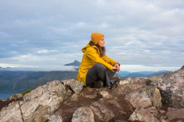 Happy family, standing on a rock and looking over Segla mountain on Senja island, North Norway. Amazing beautiful landscape and splendid nature in scandinavian country