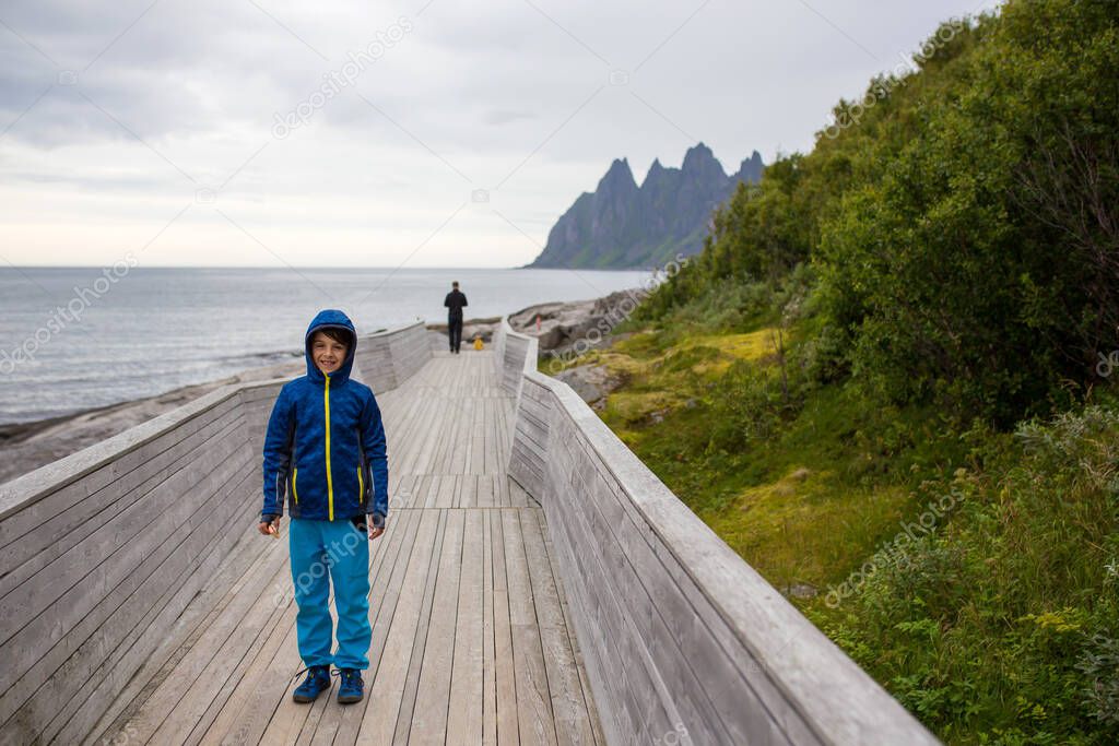 Child in Tungeneset, Senja, Norway, enjoying the beautiful view over the fjords