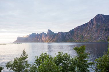 Happy family, standing on a rock and looking over Segla mountain on Senja island, North Norway. Amazing beautiful landscape and splendid nature in scandinavian country