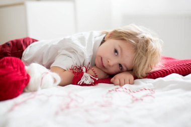 Tatlı çocuk, sarışın çocuk, beyaz ve kırmızı bileklikle oynuyor, adı Martenitsa.