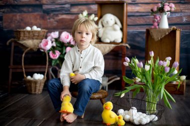 Küçük tatlı sarışın çocuk, stüdyoda paskalya süslemesi olan çocuk.