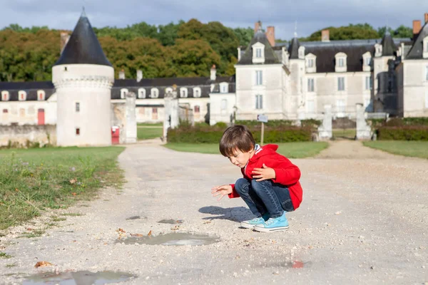 两个男孩子在法国Gizeux城堡的车道上 在雨后快乐地玩耍着 晴朗的天空 — 图库照片