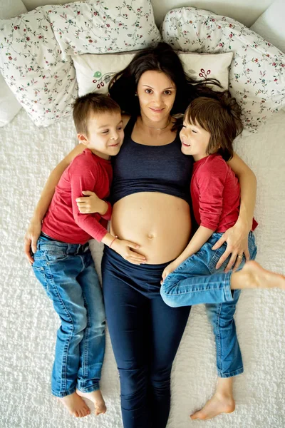 Беременная Молодая Мать Двое Детей Мальчики Лежат Постели Дома — стоковое фото