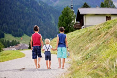 İsviçre 'de mutlu bir aile, dağda küçük bir yolda yürüyor, yaz tatiline çıkıyor.