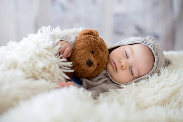 全体的なクマの男の子は甘い テディベアと一緒にベッドで寝ているぬいぐるみ 彼の後ろに冬の風景 — ストック写真