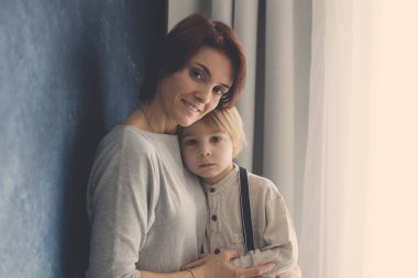 Anne ve çocuğun portresi, beyaz bir arka planda kucaklaşmalar, birlikte zaman geçirmenin keyfi.