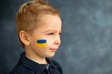 Genç sarışın çocuk, barışa destek işareti taşıyor, savaş yok, çocuk huzurlu bir hayat diliyor. Görüntü Ukrayna 'da devam eden savaşla bağlantılı