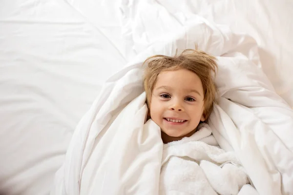 小さな金髪の幼児の子供 男の子 カメラで笑顔 ベッドのバスの後にタオルで包まれた — ストック写真
