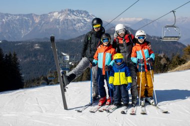 Mutlu bir aile, güneşli bir günde İtalya 'da kayak, çocuklar ve yetişkinler birlikte kayak yapıyor. Aile tatili