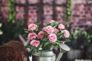 Çiçekli kova ve stüdyoda paskalya süsü, pembe güller.