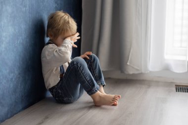 Sevimli sarışın anaokulu çocuğu, evcil köpekle yerde oturuyor, yaramazlık yaptığı için cezalandırılıyor, anneme kızgın.