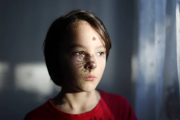10代の男の子の芸術的な肖像画 窓の横に立って カーテンからの影は彼の顔に落ち 興味深い影を作り 芸術の肖像画 — ストック写真
