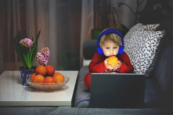 Criança Segurando Laranja Assistindo Filme Computador Noite Casa — Fotografia de Stock