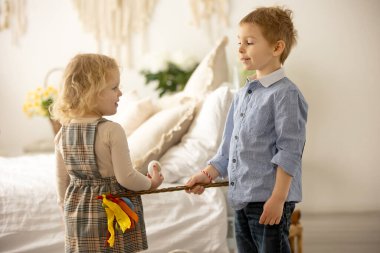 Happy children, siblings, enjoying Easter holiday together, tradition with handmade twig, braided whip made from pussy willow, traditional symbol of Czech Easter
