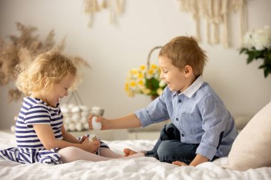 Happy children, siblings, enjoying Easter holiday together, tradition with handmade twig, braided whip made from pussy willow, traditional symbol of Czech Easter