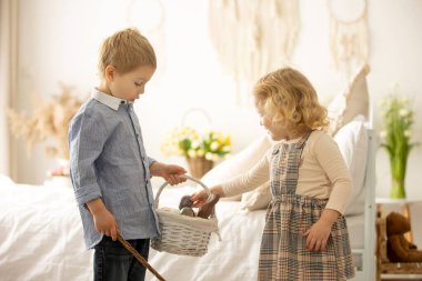 Happy children, siblings, enjoying Easter holiday together, tradition with handmade twig, braided whip made from pussy willow, traditional symbol of Czech Easter