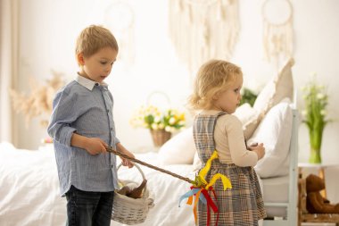 Happy children, siblings, enjoying Easter holiday together, tradition with handmade twig, braided whip made from pussy willow, traditional symbol of Czech Easter