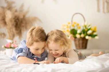 Happy children, siblings, enjoying Easter holiday together, tradition with handmade twig, braided whip made from pussy willow, traditional symbol of Czech Easter
