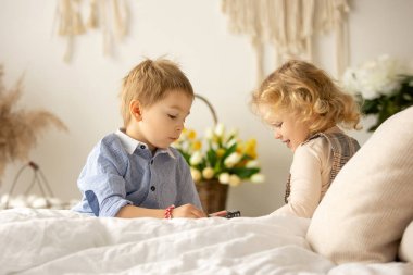 Happy children, siblings, enjoying Easter holiday together, tradition with handmade twig, braided whip made from pussy willow, traditional symbol of Czech Easter