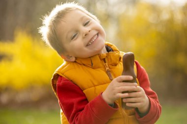 Cute preschool child, boy, holding handmade braided whip made from pussy willow, traditional symbol of Czech Easter used for whipping girls and women to receive eggs and sweets
