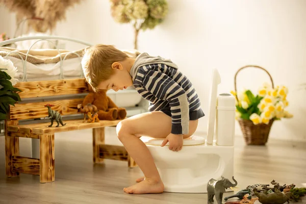 Criança Bonito Menino Usando Potty Casa Enquanto Brincava Com Brinquedos — Fotografia de Stock