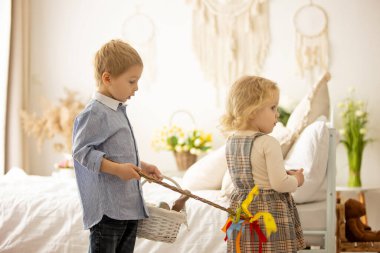 Happy children, siblings, enjoying Easter holiday together, tradition with handmade twig, braided whip made from pussy willow, traditional symbol of Czech Easter