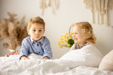 Happy children, siblings, enjoying Easter holiday together, tradition with handmade twig, braided whip made from pussy willow, traditional symbol of Czech Easter