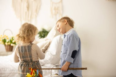 Happy children, siblings, enjoying Easter holiday together, tradition with handmade twig, braided whip made from pussy willow, traditional symbol of Czech Easter