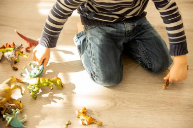 Küçük çocuk, çocuk, oyuncaklarla oynarken pantolonuna işe, çocuğun dikkati dağılsın ve evdeki tuvalete gitmeyi unutsun.