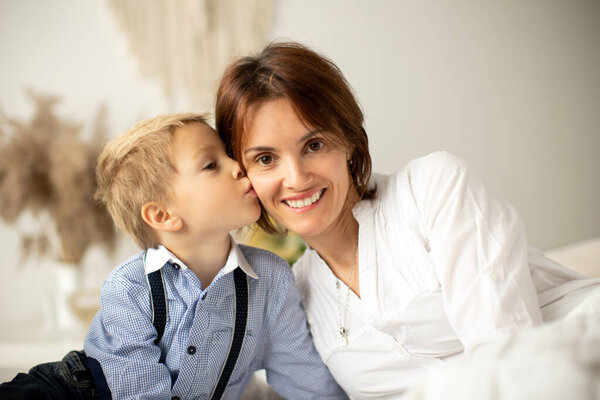 Mother and child, blond fashion preschool boy, having a wonderful family happy moment together, enjoying the relation
