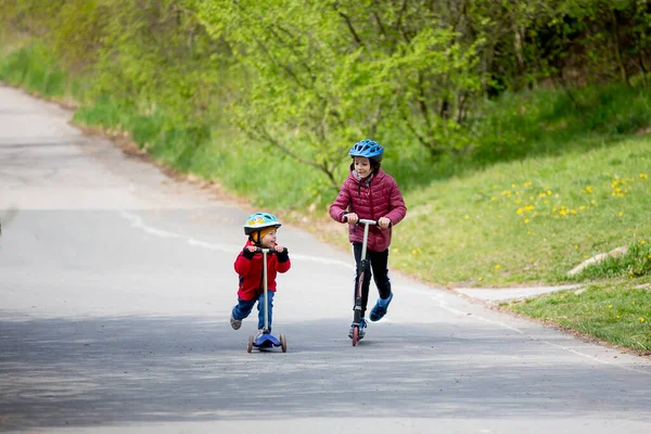 Children Brothers Riding Scooters Park Together Spring Sunny Day — Stock Photo, Image