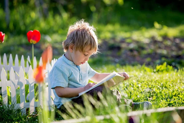 Güzel Sarışın Çocuk Tişörtlü Tatlı Çocuk Gün Batımında Bahçede Kitap — Stok fotoğraf