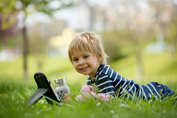 Mooi Kind Blonde Jongen Spelen Tablet Het Park Fles Water — Stockfoto