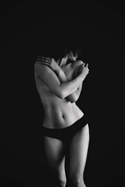 Naked woman on black background, act photo