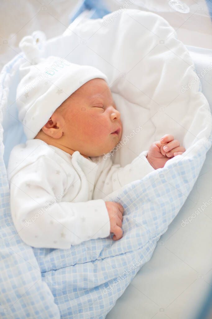 Beautiful newborn baby boy, laying in crib in prenatal hospital