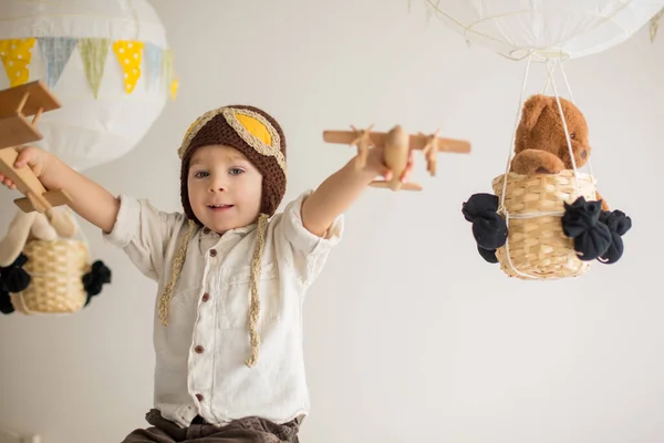 飛行機やテディベアで遊んでいる甘い幼児の男の子は 彼の後ろにおもちゃで気球を飾りました — ストック写真