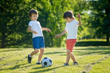 Birlikte futbol oynayan iki sevimli küçük çocuk, yaz. Çocuklar futbol açık oyun